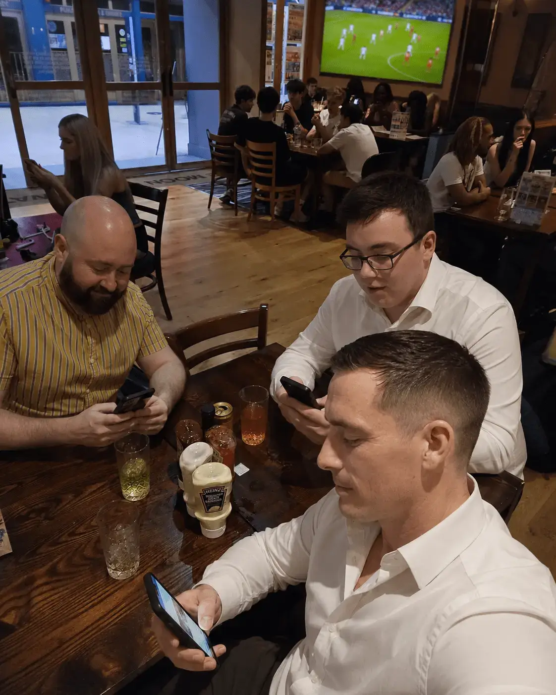 Hombres en un bar mirando el celular